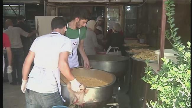 Photo of Syrian volunteers cook meals to help poor people